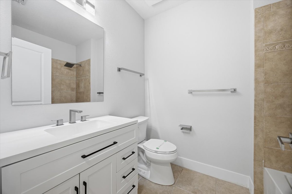 Primary bath vanity area with framed mirror and designer fixtures