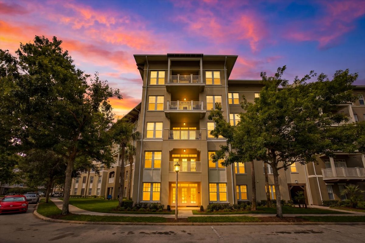 Building entry glowing at twilight with a vivid sunset sky over 1211 Stonecutter Drive